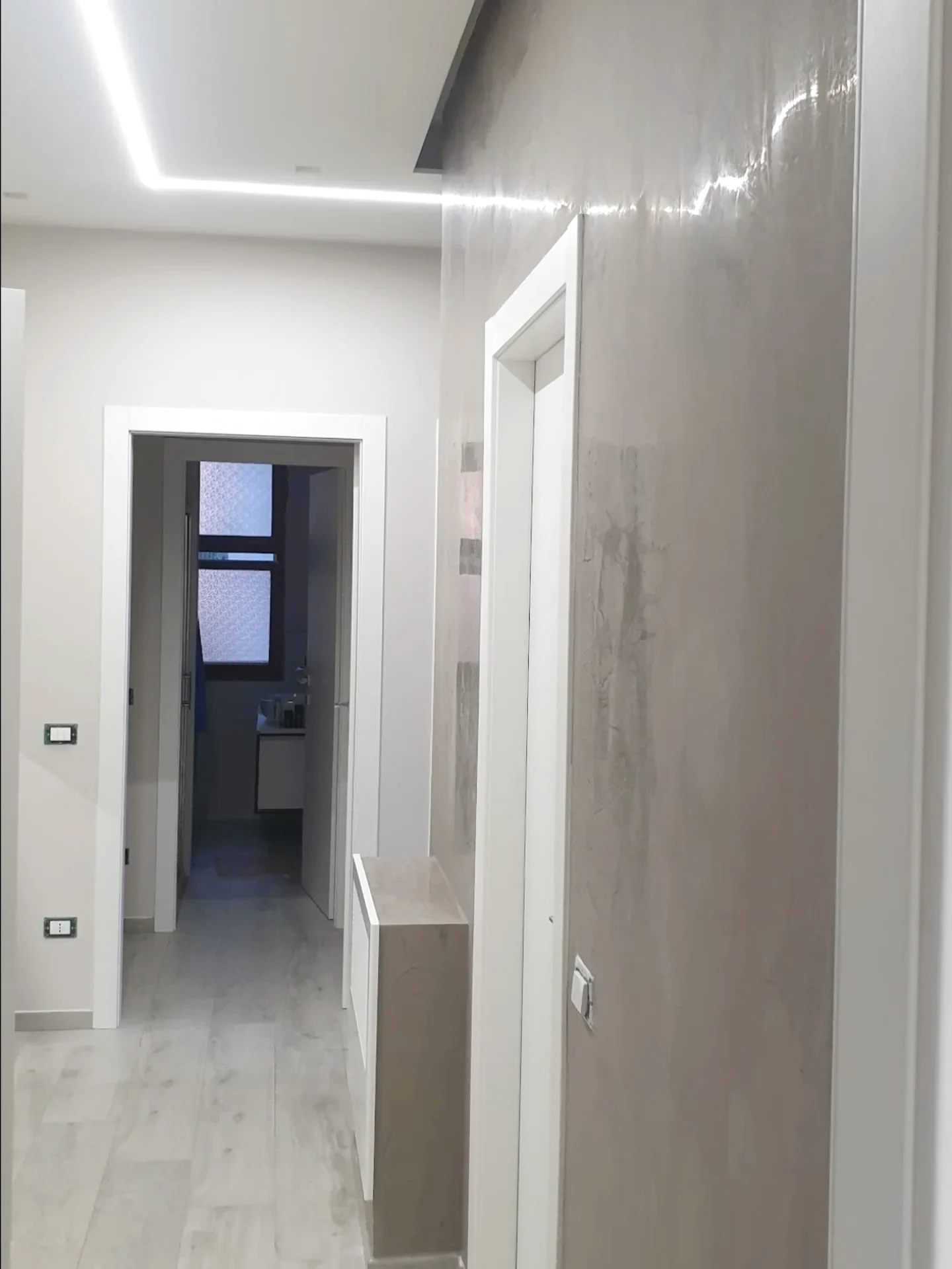 Disimpegno rifinito con porte, controsoffitto e illuminazione